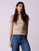 Remera color beige de tejido acanalado, con escote a la base y manga corta.