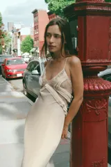 Vestido largo de georgette con escote en pico, tirantes finos cruzados en la espalda y detalle de volantes aplicados en el pecho.