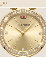 Reloj de pulsera analógico para mujer, con caja redonda de metal dorado y bisel decorado con cristales. Presenta una esfera minimalista en tono dorado con manecillas finas y una malla de eslabones metálicos a juego.