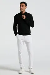 Sweater de punto color negro, con cuello alto y cierre frontal parcial de un cuarto. Presenta mangas largas con puños acanalados y el logo de la marca bordado en el pecho.