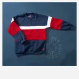 Buzo de felpa azul marino, rojo y blanco con diseño de bloques de color.