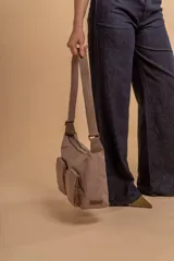 Bandolera de tafeta impermeable color beige, con dos bolsillos frontales con cierre y correa regulable. Diseño práctico y liviano ideal para uso diario.