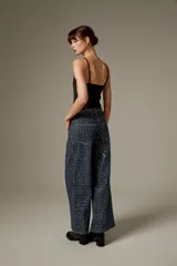 Pantalón jean ancho de tiro medio, completamente revestido con lentejuelas azul oscuro, de corte recto y cinco bolsillos.