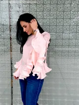 Blusa color rosa pálido de gasa con volados en las mangas y en el ruedo.