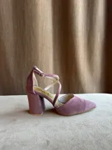 Zapatos de tacón bajo en tela color malva, con punta fina, taco ancho de 5 cm, escote en V y tiras cruzadas en diagonal con cierre de hebilla en el tobillo.