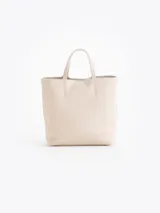 Cartera tipo tote bag pequeña de cuero vacuno negro con diseño de abejas grabadas en bajo relieve. Cuenta con doble asa de mano, correa ajustable y un tag colgante con dije metálico en forma de abeja.
