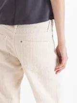 Pantalon de sarga jacquard desgastada de algodón texturado, con corte estilo jean, tiro bajo y diseño largo. Cuenta con bolsillos delanteros y traseros, y detalles de hilos de fantasía tipo bouclé.