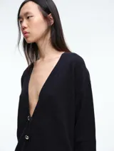 Cardigan de punto color marrón oscuro, con escote en V, manga larga y cierre frontal con botones metálicos dorados.