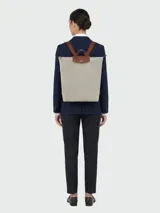 Mochila Longchamp modelo Le Pliage Original tamaño M, de color negro con detalles en cuero marrón y herrajes dorados. Cuenta con solapa con botón a presión, cierre superior y correas ajustables.