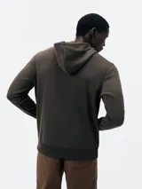 Buzo con capucha de corte clásico, confeccionado en tejido de algodón, con bolsillo frontal tipo canguro y puños acanalados.