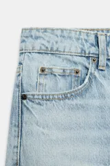Jeans wide leg de tiro alto y cinco bolsillos, confeccionados en denim con lavado azul medio y efecto desgastado. Presenta cierre frontal con cremallera y botón metálico.