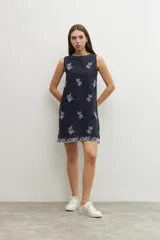 Vestido corto azul marino con bordado floral blanco, sin mangas y corte recto.