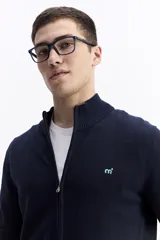 Campera tejida de algodón en color beige, con cierre frontal completo, cuello levemente elevado y puños y ruedo acanalados. Presenta un pequeño logo bordado en el pecho.