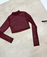 Polera crop de tul traslúcido color bordó, con cuello alto y mangas largas.