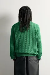 Sweater de punto verde con diseño de trenzas, cuello redondo y manga larga, de corte regular fit y acabados en rib.
