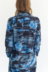 Sobrecamisa de micropana con estampado abstracto en tonos azules y negros. Tiene mangas largas con puños, cuello camisero y cierre frontal con botones.