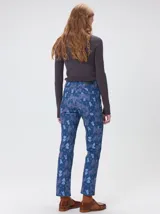 Pantalón de jean de tiro medio con corte de pierna recta y ajuste cómodo. Presenta un estampado integral con motivos geométricos y abstractos en tonos azules.