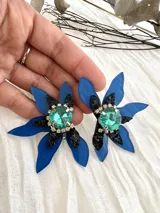 Aros colgantes con forma de flor, con pétalos azules y centro con strass verde.