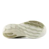 Championes New Balance de estilo urbano y deportivo, color beige con detalles en blanco. Presentan una entresuela gruesa con tecnología Fresh Foam X para mayor amortiguación y un empeine de malla transpirable con el logo característico en el lateral.