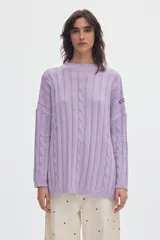 Buzo tejido de algodón color lila, con cuello alto, diseño oversized, detalles de ochos en relieve, tajos laterales y parche de la marca en la manga.