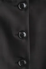 Blazer entallado negro con escote cuadrado, botonadura frontal y hombreras finas.