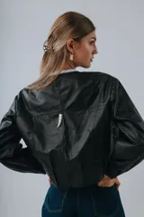 Campera bomber de cuero color marrón, con mangas abullonadas, puños elásticos y cierre frontal con botones a presión.