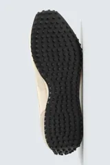Zapatilla de estilo retro con cordones, confeccionada en tejido técnico y detalles de cuero con acabado serraje. Presenta suela dentada con contraste de color.
