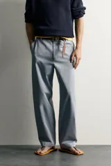 Pantalón chino para hombre de corte relajado, confeccionado en tejido de algodón con efecto lavado en color celeste. Cuenta con bolsillos delanteros, bolsillos traseros de vivo con botón y cierre frontal con cremallera y botón.