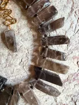 Collar corto con piedras de citrino natural en bruto con corte rectangular en tonos marrones y humo, montadas sobre cadena dorada y eslabones de extensión.
