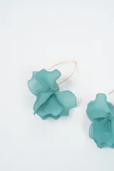 Aros colgantes con diseño de flor en color negro, con gancho metálico dorado.