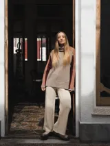 Buzo tejido de punto color crema con cuello alto y mangas largas con rayas horizontales en verde y lila.