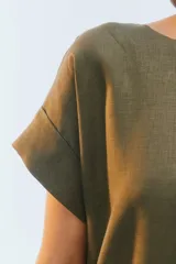 Vestido midi evasé color azul, confeccionado en lino, con escote redondo, mangas cortas con dobladillo vuelto y bolsillos laterales. Presenta un ruedo asimétrico, más largo en los laterales.