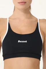 Top deportivo negro con breteles blancos y logo Basset estampado en el frente.
