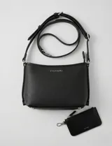 Cartera tipo bandolera Tahari color azul, con diseño estructurado y cierre metálico superior. Incluye una correa larga regulable y un mini monedero independiente enganchado a la misma. Presenta logo metálico frontal y herrajes plateados.