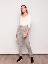 Pantalón tipo babucha de corte deportivo, color beige, con cintura elástica ajustable mediante cordón, puños en los tobillos y bolsillos frontales.