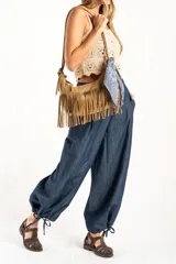 Pantalón tipo jean de corte wide leg y diseño balloon, con cintura elástica y cordones ajustables en los tobillos. Confeccionado en algodón denim de tono azul oscuro.