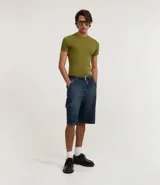 Bermuda de hombre en denim de algodón, modelo cargo, corte baggy y tiro medio. Presenta bolsillos laterales tipo cargo y cierre tradicional con botón y cremallera.