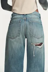 Jeans de tiro bajo y cinco bolsillos, de pierna ancha y larga. Cuenta con cierre frontal con cremallera y botón metálico.