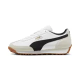 Championes urbanos Puma modelo Easy Rider Mix, color blanco con detalles en negro y beige. Presentan un diseño retro con capellada de cuero y gamuza, logo Puma dorado en el lateral y suela de goma dentada color caramelo.