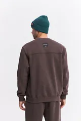 Buzo de algodón color marrón chocolate, con cuello redondo, mangas largas y estampa frontal con el nombre de la marca repetido en tono sobre tono.