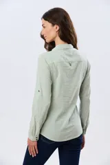 Camisa de lino lisa color celeste, de manga larga con puños abotonados y trabilla para arremangar. Cuenta con cuello clásico, cierre frontal con botones y bolsillos plaqué en el pecho.