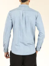 Camisa de manga larga estilo denim, con corte slim fit, cuello buttondown y bolsillo frontal.