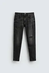 Jeans skinny fit de corte ajustado y tiro medio en color negro con efecto lavado y detalles desgastados. Confeccionados en tejido elástico con mezcla de algodón, presentan diseño clásico de cinco bolsillos y cierre frontal con cremallera y botón.