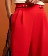 Pantalón wide leg de sastrería color rojo, de cintura alta con aletas abotonadas, pliegues y pinzas.