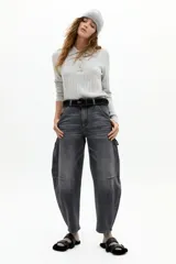 Pantalón de denim con corte barrel relajado y tiro medio, confeccionado en algodón con spandex. Presenta un estampado floral integral sobre fondo negro.