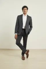 Ambo de corte slim en color gris oscuro con microdiseño, compuesto por saco de dos botones y pantalón de vestir. Confeccionado con tejido que incluye elastano para mayor flexibilidad y confort.