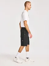 Short cargo negro Cat con cintura elástica y cordón de ajuste, múltiples bolsillos incluyendo bolsillos laterales con solapa y cierre de cremallera.