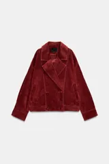 Cazadora de ante con cuello de solapa, cierre frontal cruzado con botones forrados y bajo elástico. Presenta mangas largas con trabillas en los puños y bolsillos laterales de vivo.