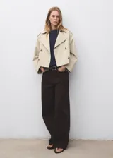Chaqueta crop de doble botonadura color beige, con cuello pico con solapa, mangas largas y dos bolsillos laterales.
