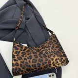 Cartera marrón con estampado animal print de leopardo, con correa corta para llevar al hombro.
